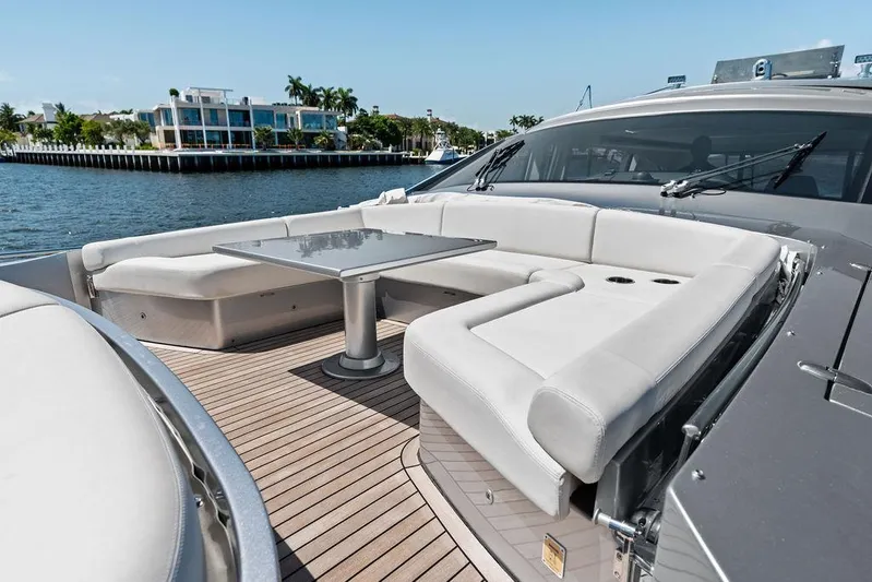 Phoenix Rising Yacht Photos Pics Luxurious 2017 Pershing 82 yacht with elegant outdoor seating and table on deck.