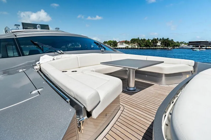 Phoenix Rising Yacht Photos Pics Luxurious 2017 Pershing 82 yacht deck with seating and table, overlooking serene waterfront.