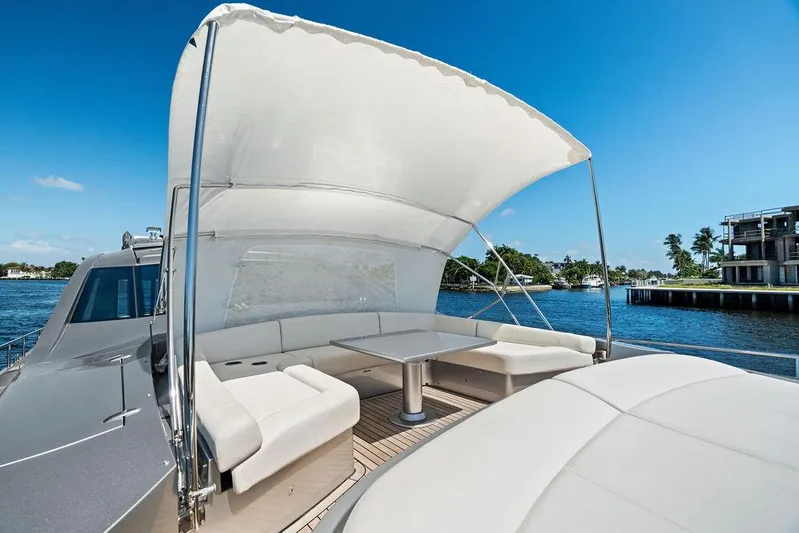 Phoenix Rising Yacht Photos Pics Luxury 2017 Pershing 82 yacht deck with seating and canopy, cruising on a sunny day.