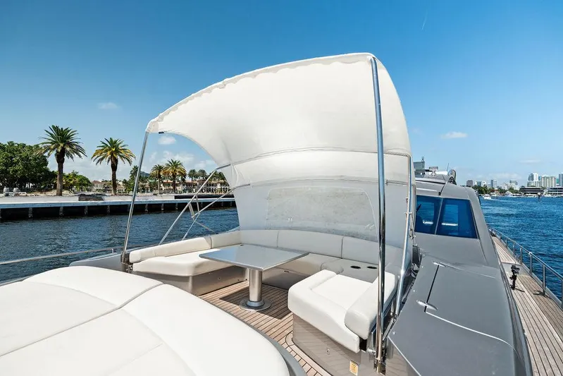 Phoenix Rising Yacht Photos Pics Luxurious 2017 Pershing 82 yacht with shaded seating area, cruising near palm-lined shore.