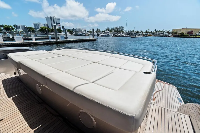 Phoenix Rising Yacht Photos Pics Luxury sunbed on 2017 Pershing 82 yacht, docked at marina with cityscape view.