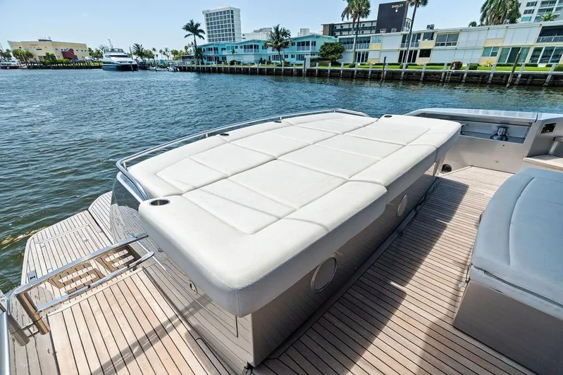 Phoenix Rising Yacht Photos Pics Luxurious 2017 Pershing 82 yacht deck with sunbed, overlooking waterfront buildings.