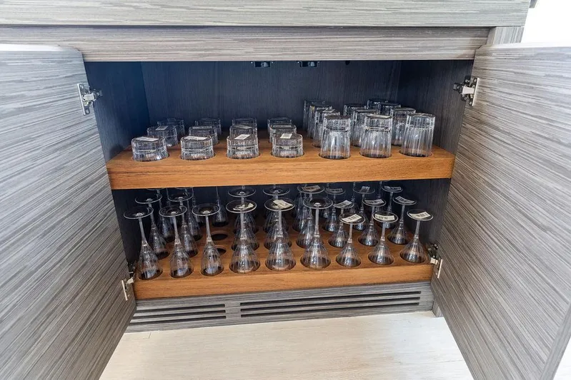 Phoenix Rising Yacht Photos Pics Glassware storage in a 2017 Pershing 82 yacht cabinet, featuring neatly arranged glasses.