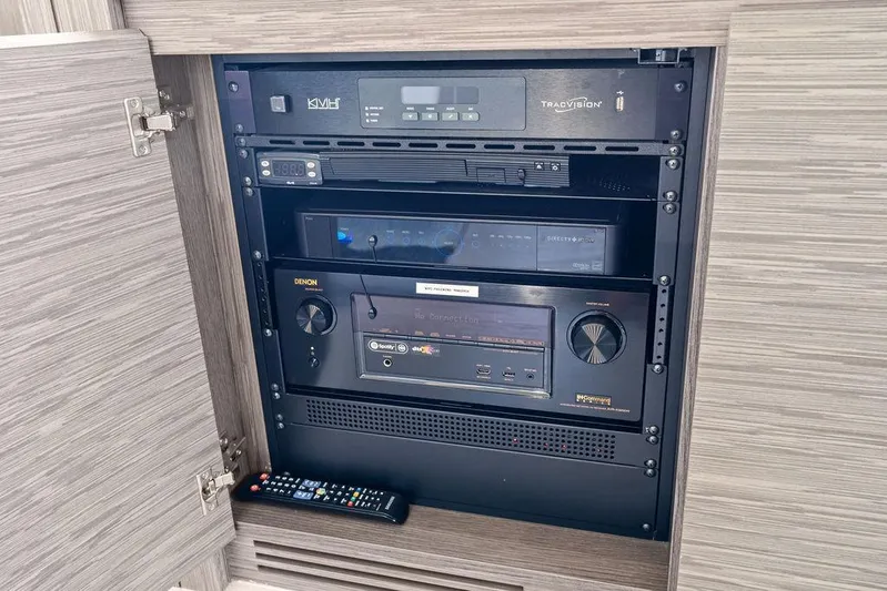 Phoenix Rising Yacht Photos Pics Audio-visual equipment cabinet on a 2017 Pershing 82 yacht, featuring Denon and TracVision systems.