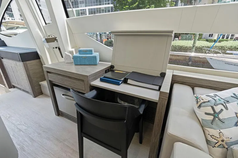 Phoenix Rising Yacht Photos Pics Luxurious interior of a 2017 Pershing 82 yacht with modern desk and seating area.