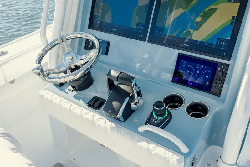  Yacht Photos Pics 2025 Yellowfin 32 boat dashboard with steering wheel and navigation screens.