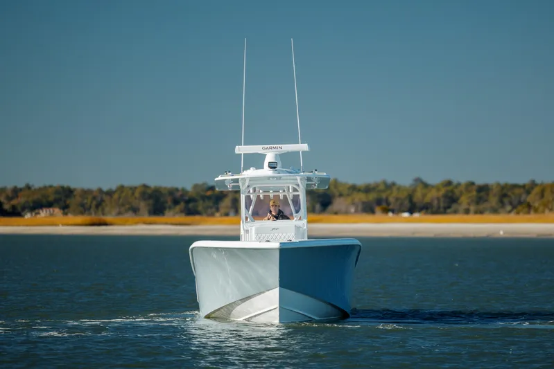  Yacht Photos Pics 2025 Yellowfin 32 boat cruising on calm water, clear sky background.