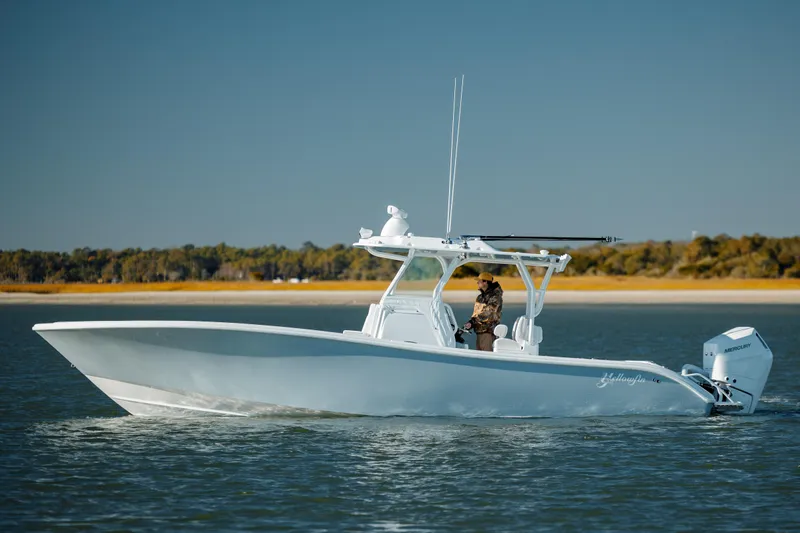  Yacht Photos Pics 2025 Yellowfin 32 boat cruising on calm water with scenic background.