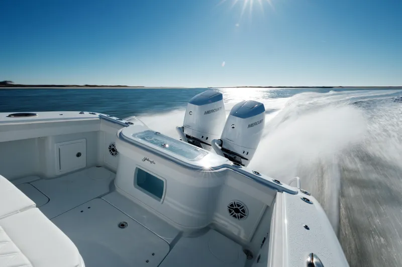  Yacht Photos Pics 2025 Yellowfin 32 boat speeding on open water under clear blue sky.