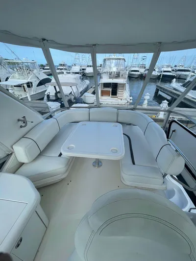 Get N Free Yacht Photos Pics 2006 Sea Ray 44 Sedan Bridge yacht interior with white seating and table, docked at marina.