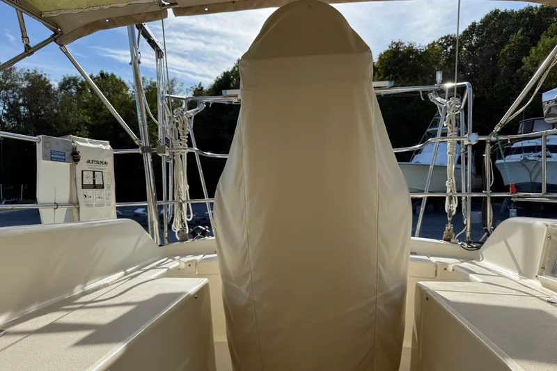 Via Yacht Photos Pics 2004 Caliber 40LRC sailboat cockpit with covered helm, surrounded by trees and clear sky.
