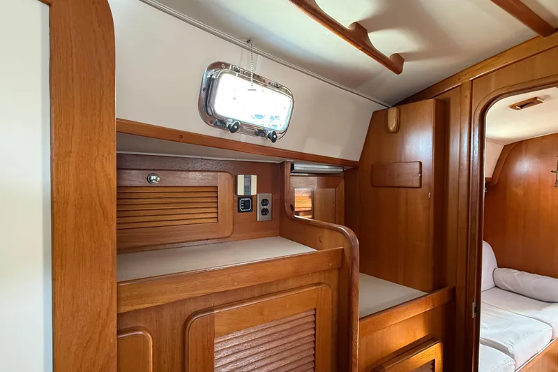 Via Yacht Photos Pics Interior of 2004 Caliber 40LRC sailboat with wooden cabinetry and cozy seating area.