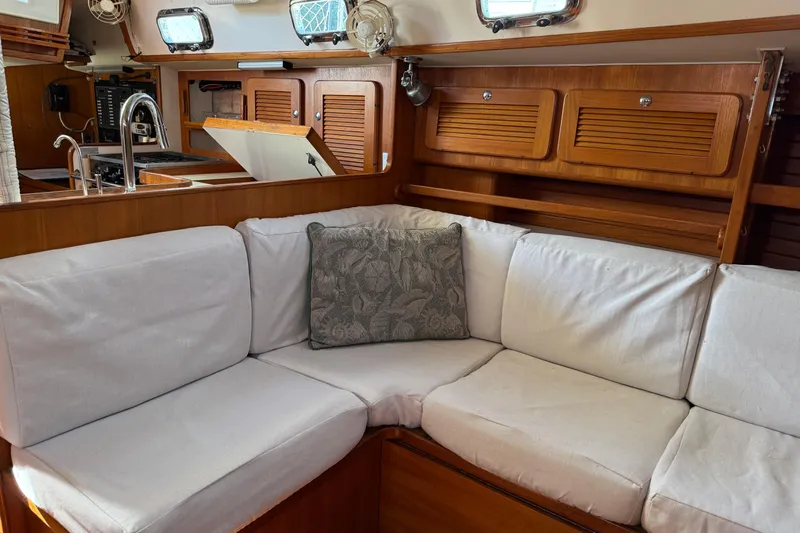 Via Yacht Photos Pics Interior of 2004 Caliber 40LRC yacht with cozy seating and wooden cabinetry.