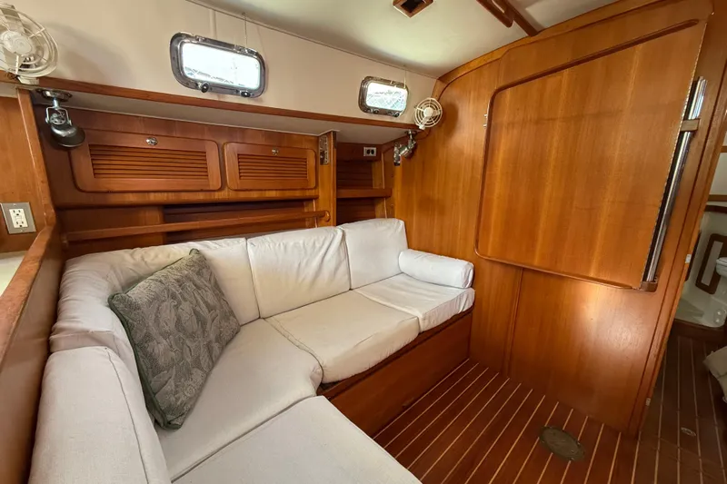 Via Yacht Photos Pics Cozy interior of 2004 Caliber 40LRC yacht with wooden paneling and cushioned seating.