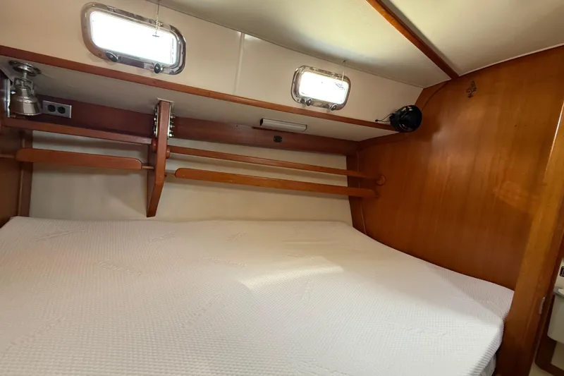 Via Yacht Photos Pics Cozy cabin interior of 2004 Caliber 40LRC sailboat with wooden accents and porthole windows.