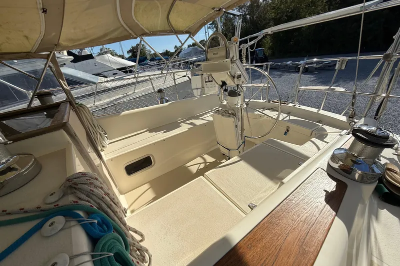 Via Yacht Photos Pics 2004 Caliber 40LRC sailboat cockpit with steering wheel, ropes, and winches in marina setting.