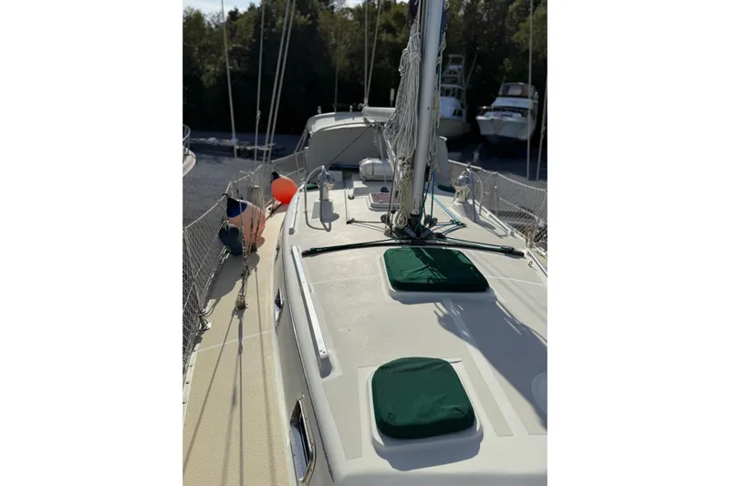 Via Yacht Photos Pics 2004 Caliber 40LRC sailboat deck with green covers and rigging, docked near trees.