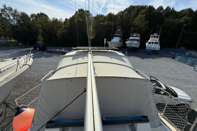 Via Yacht Photos Pics 2004 Caliber 40LRC sailboat in a boatyard, surrounded by trees and other vessels.