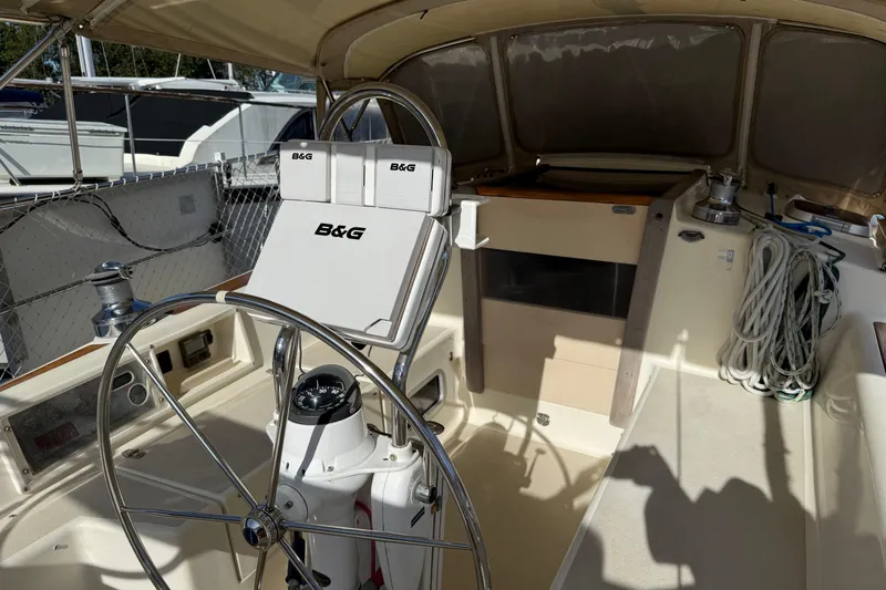 Via Yacht Photos Pics 2004 Caliber 40LRC yacht cockpit with steering wheel, navigation equipment, and rope storage.