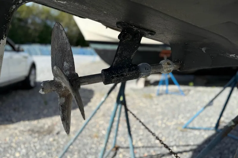 Via Yacht Photos Pics Close-up of a 2004 Caliber 40LRC boat propeller on a gravel surface.