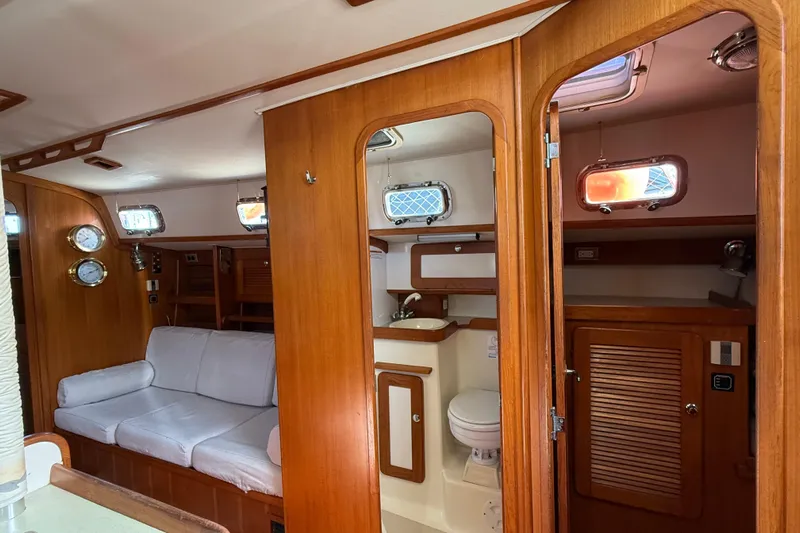 Via Yacht Photos Pics Interior of 2004 Caliber 40LRC yacht with wooden finish and cozy seating area.