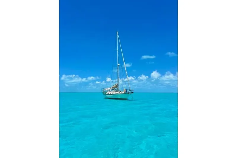 Via Yacht Photos Pics Sailboat Caliber 40LRC 2004 on clear turquoise water under a bright blue sky.