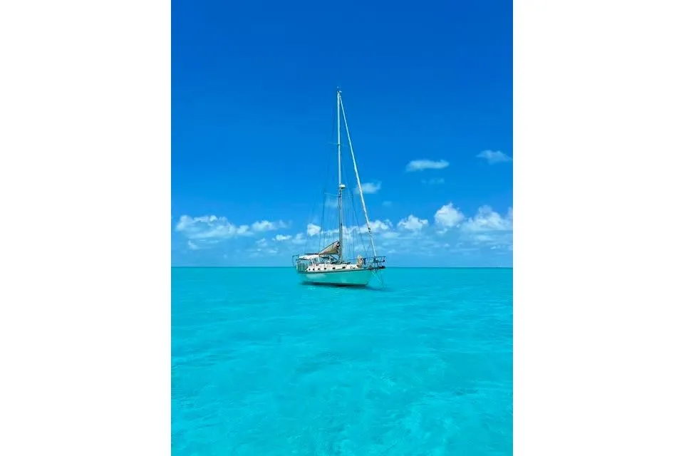 Sailboat Caliber 40LRC 2004 on clear turquoise water under a bright blue sky.
