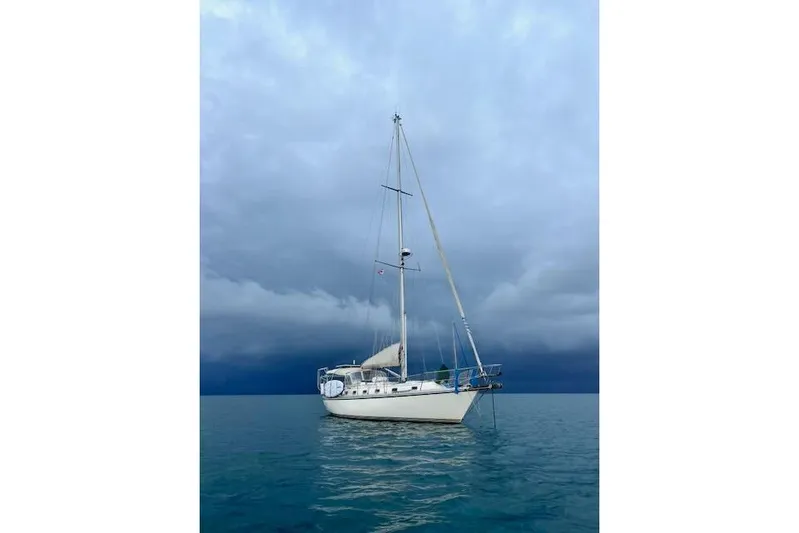 Via Yacht Photos Pics Sailboat Caliber 40LRC 2004 on calm water under cloudy sky.