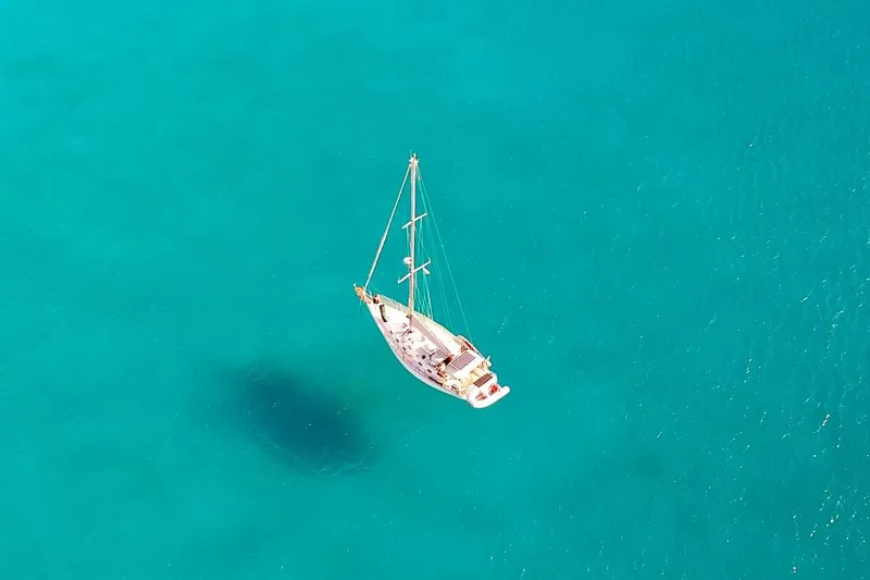 Via Yacht Photos Pics Aerial view of 2004 Caliber 40LRC sailboat on clear turquoise water.