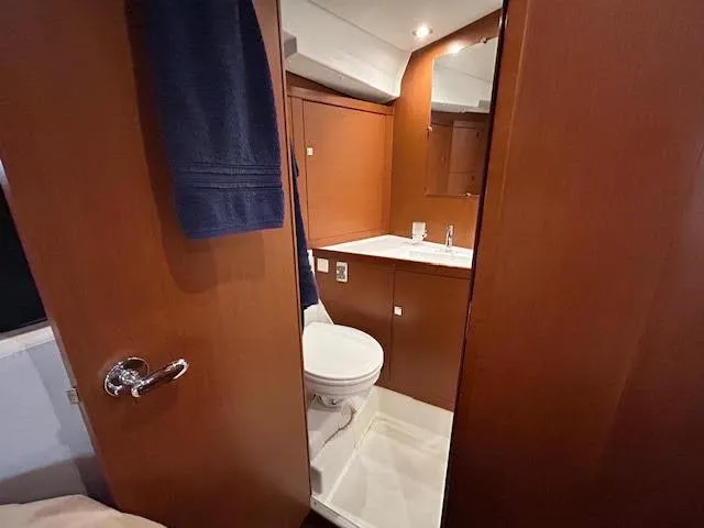  Yacht Photos Pics Interior of 2016 Beneteau Oceanis 45 yacht bathroom with wooden cabinetry and modern fixtures.