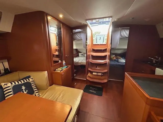  Yacht Photos Pics Interior of 2016 Beneteau Oceanis 45 yacht, featuring cozy seating and wooden finishes.