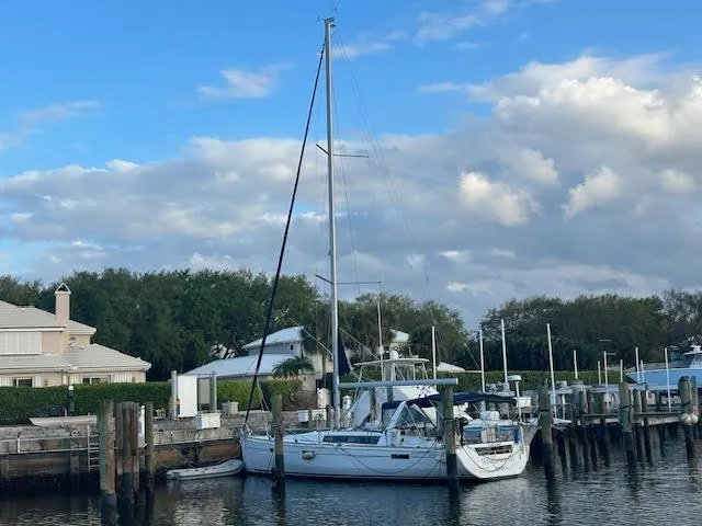  Yacht Photos Pics 2016 Beneteau Oceanis 45 sailboat docked at a marina under a cloudy sky.