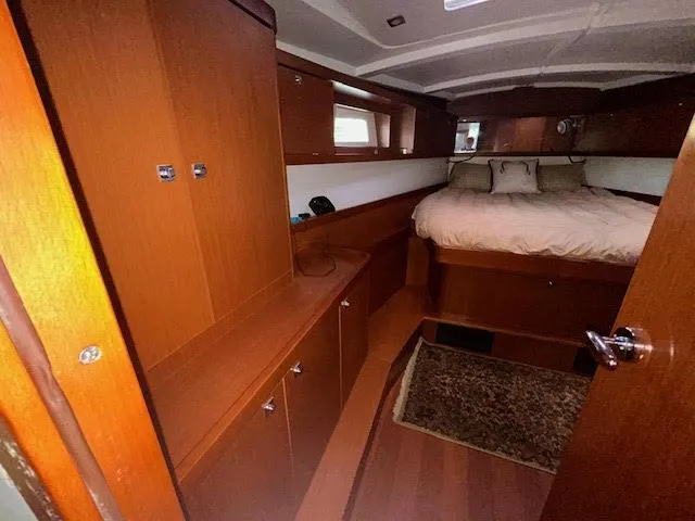  Yacht Photos Pics Interior cabin of 2016 Beneteau Oceanis 45 yacht with wooden furnishings and bed.