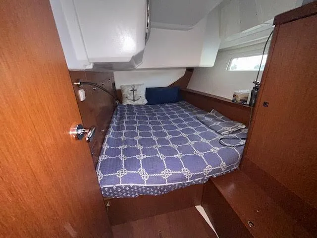  Yacht Photos Pics Cabin interior of 2016 Beneteau Oceanis 45 with nautical-themed bedding.
