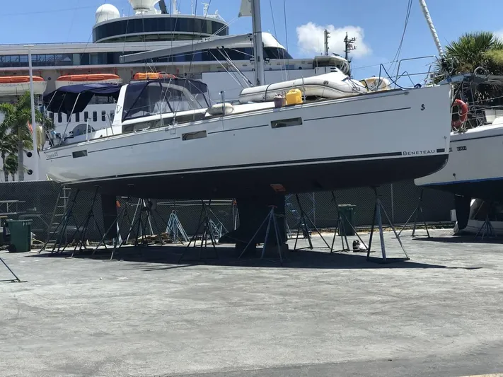  Yacht Photos Pics 2016 Beneteau Oceanis 45 sailboat on stands in a marina, with cruise ship background.