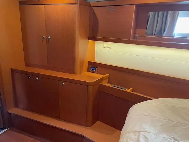  Yacht Photos Pics Interior of 2016 Beneteau Oceanis 45 yacht, featuring wooden cabinetry and cozy sleeping area.