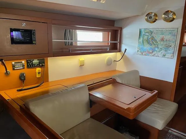  Yacht Photos Pics Interior of 2016 Beneteau Oceanis 45 yacht with navigation station and seating area.