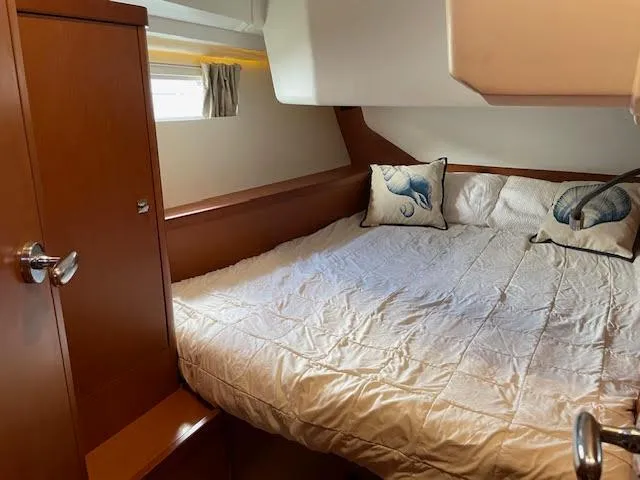  Yacht Photos Pics Cozy bedroom in 2016 Beneteau Oceanis 45 yacht with plush bedding and decorative pillows.