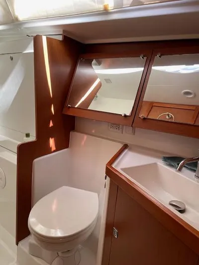  Yacht Photos Pics 2016 Beneteau Oceanis 45 yacht bathroom with modern fixtures and wooden cabinetry.