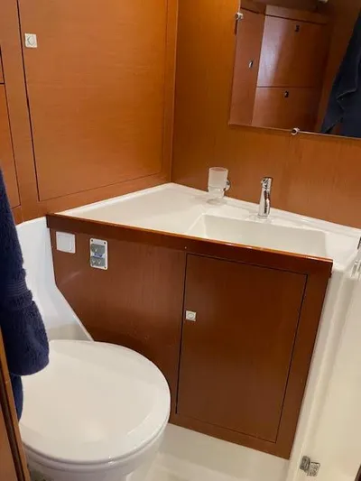  Yacht Photos Pics 2016 Beneteau Oceanis 45 bathroom with wooden cabinetry and modern fixtures.