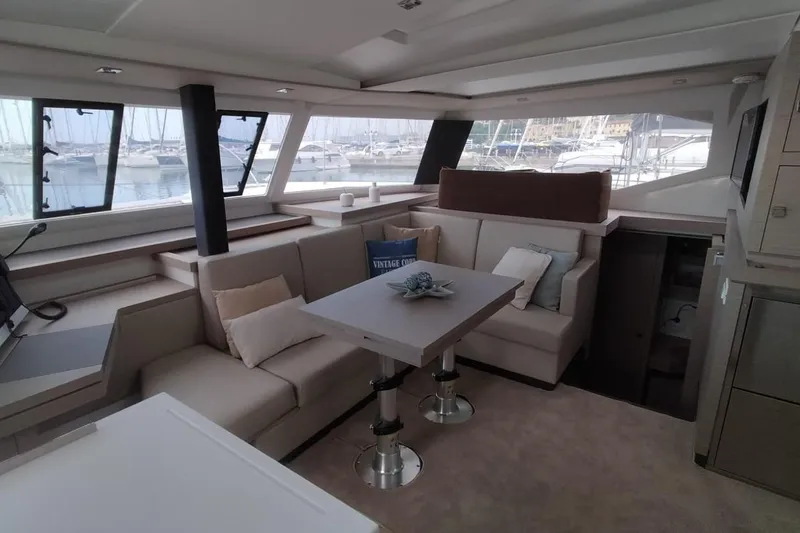  Yacht Photos Pics Luxurious interior of 2021 Fountaine Pajot Catamaran Astrea 42 with elegant seating and table.