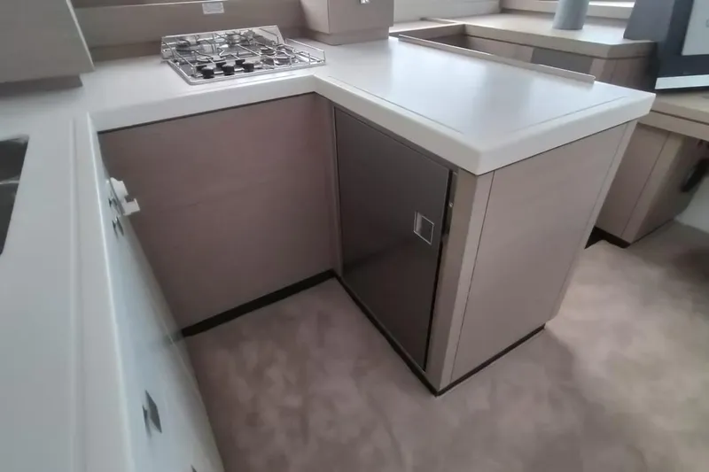  Yacht Photos Pics Modern kitchen interior of 2021 Fountaine Pajot Catamaran Astrea 42 with stove and cabinetry.