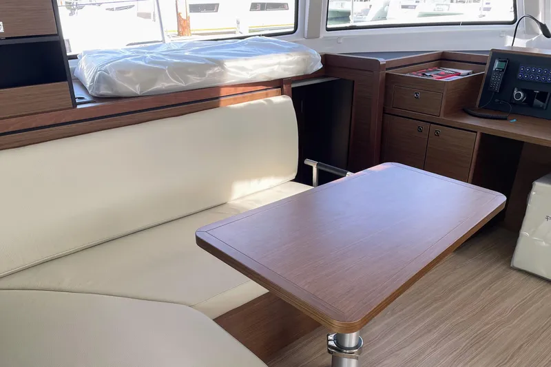  Yacht Photos Pics Luxurious interior of 2022 Nautitech 44 Open catamaran with wooden table and seating.