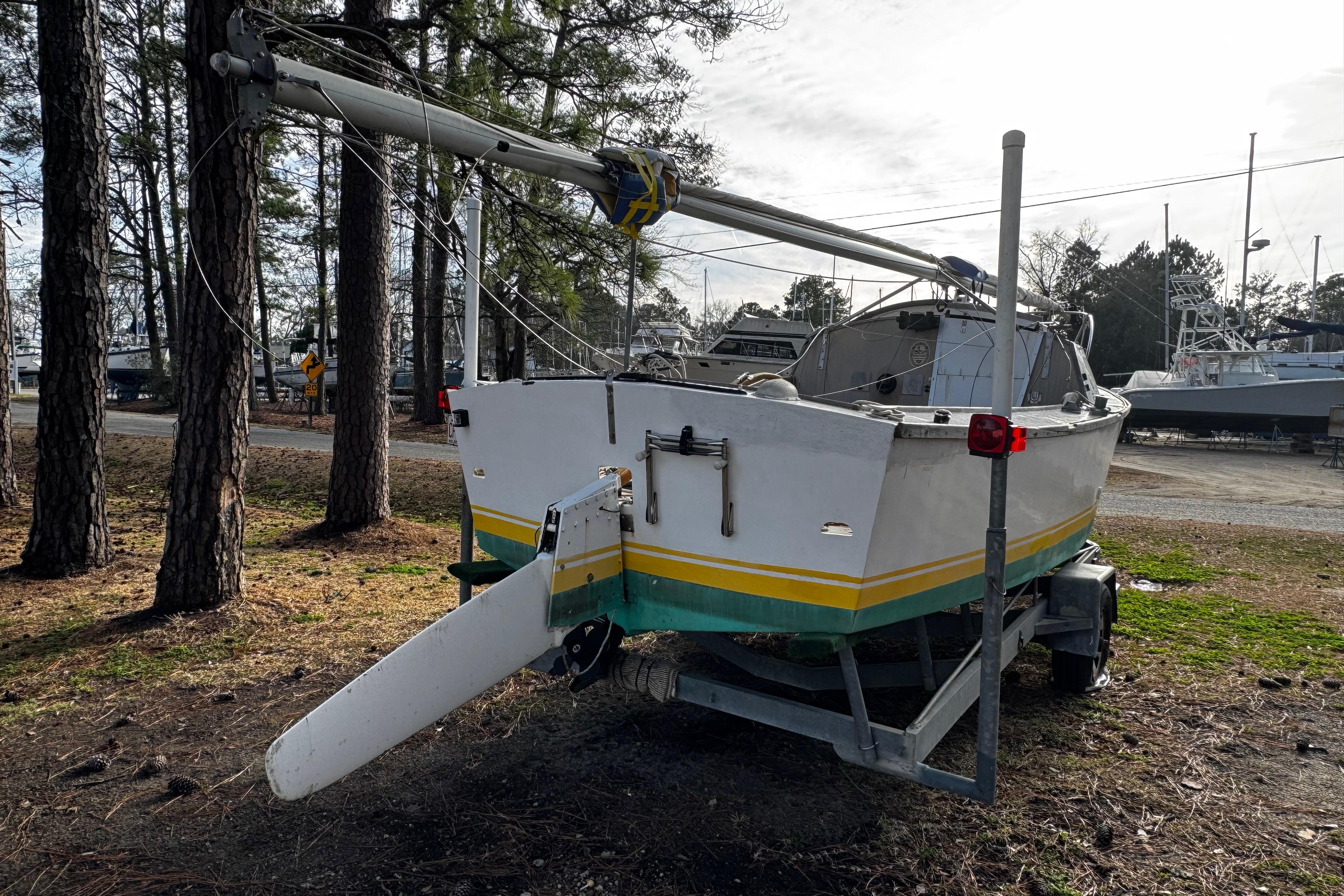 1976 Custom Wooden Sloop on trailer, surrounded by trees and other boats.