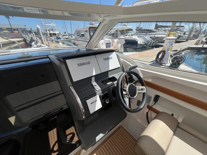 Mdr #297 In Stock Yacht Photos Pics 2024 Nimbus W9 boat cockpit with Simrad navigation system, docked at marina.