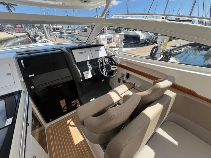 Mdr #297 In Stock Yacht Photos Pics 2024 Nimbus W9 boat interior with modern dashboard and comfortable seating at marina.