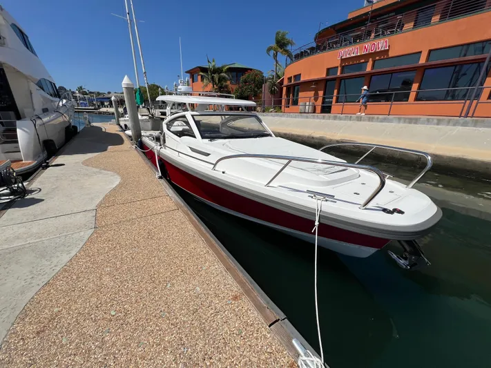 Mdr #297 In Stock Yacht Photos Pics 2024 Nimbus W9 boat docked at a marina with modern architecture.