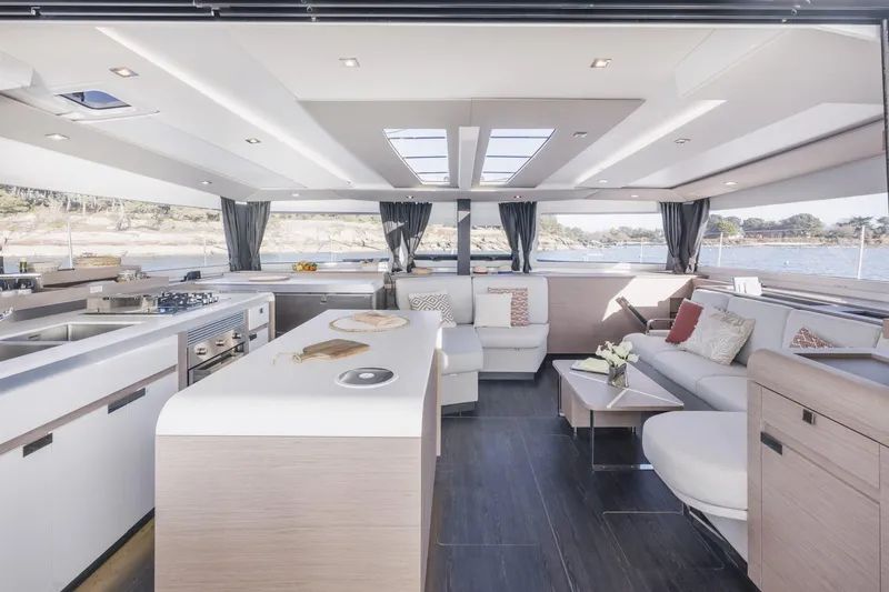  Yacht Photos Pics Luxurious interior of 2025 Fountaine Pajot Catamaran Aura 51 with modern kitchen and seating area.