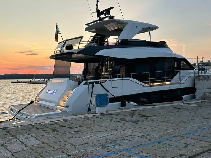  Yacht Photos Pics 2024 Cranchi 67 FLY yacht docked at sunset, showcasing sleek design and modern features.
