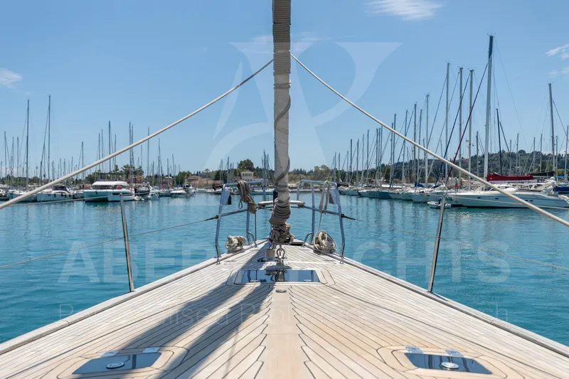 Satori Yacht Photos Pics Bow view of 2005 Farr 64 yacht in a marina with clear blue water.
